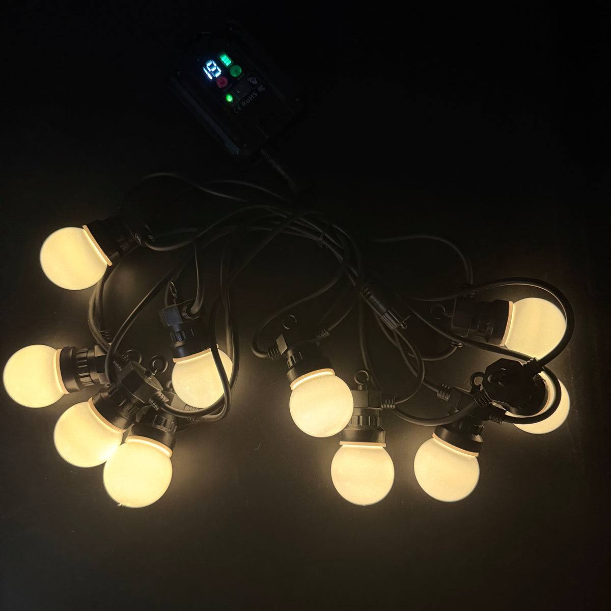 LED globe string lights glowing warm white in dark setting
